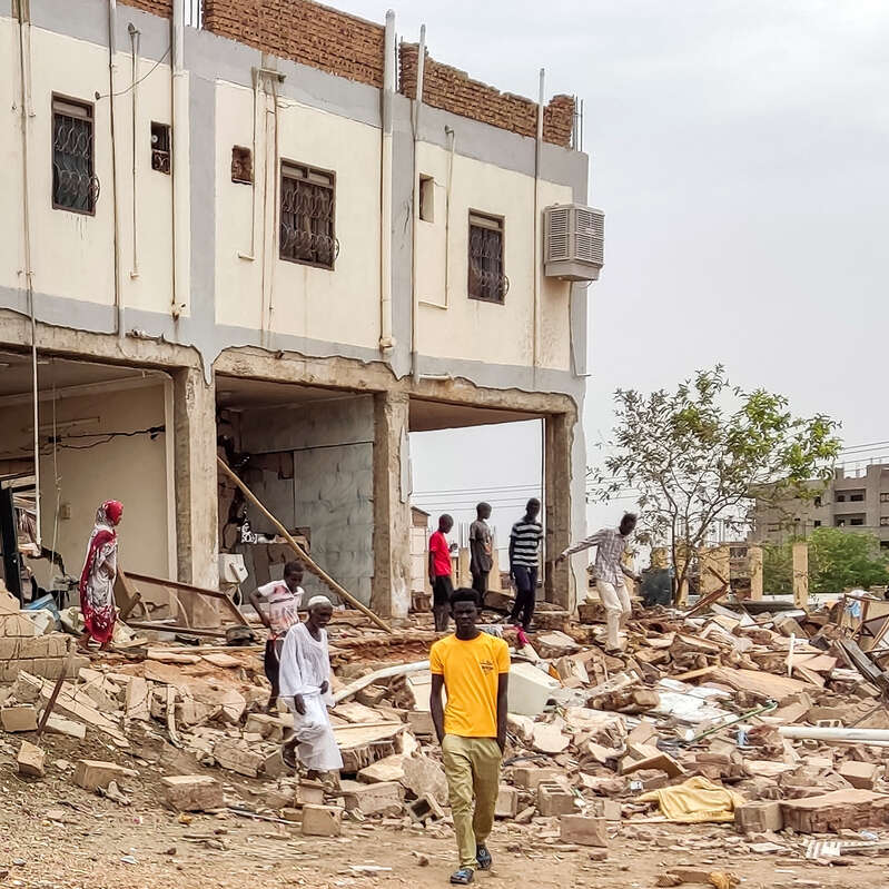 People inspect the war damage to a residential building in the Azhari district of Khartoum, Sudan. 