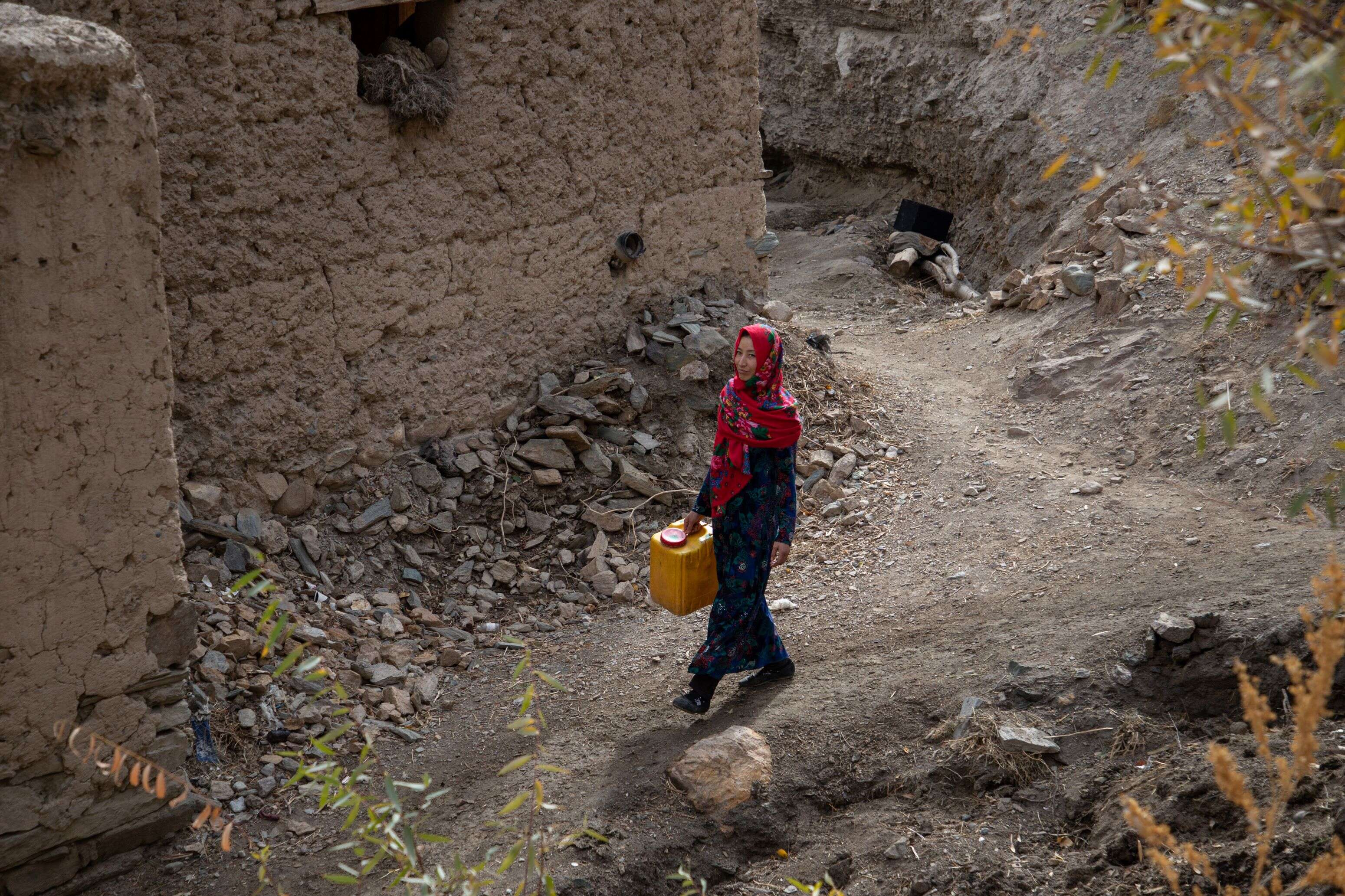 Rozama, 27, walks towards the river to collect water in Sabzaab Bala village, Bamiyan province, Afghanistan.