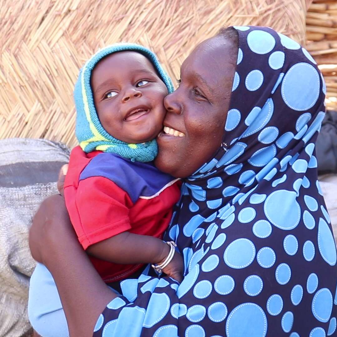 Domo holds her 8-month-old son, Ichaou, in the courtyard of their makeshift home built in the middle of the Ouallam IDP site. Oualla, Tillabéri, Niger.