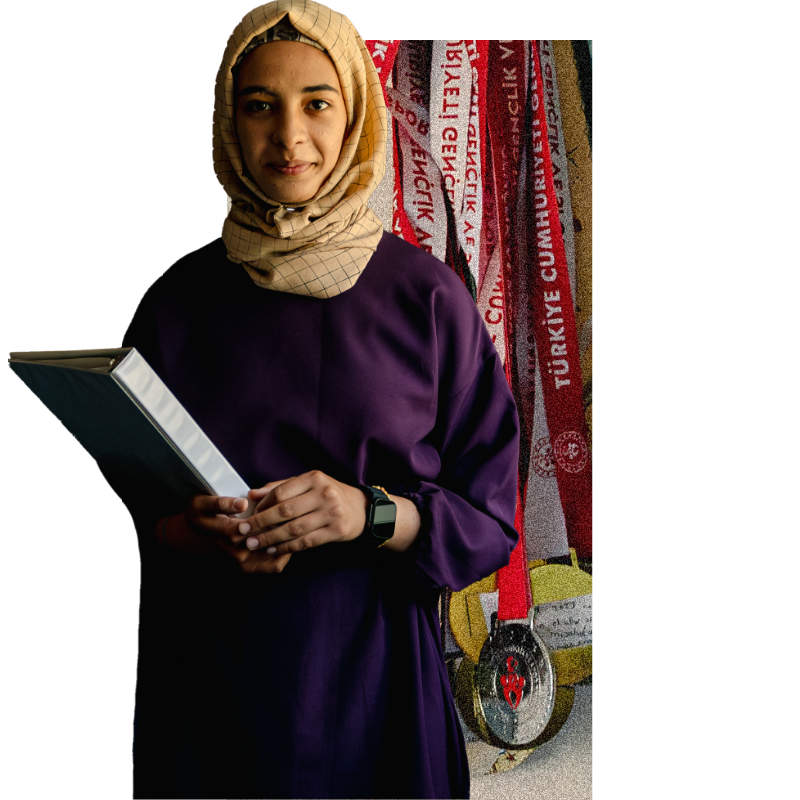 Samira holding books and looking into the camera