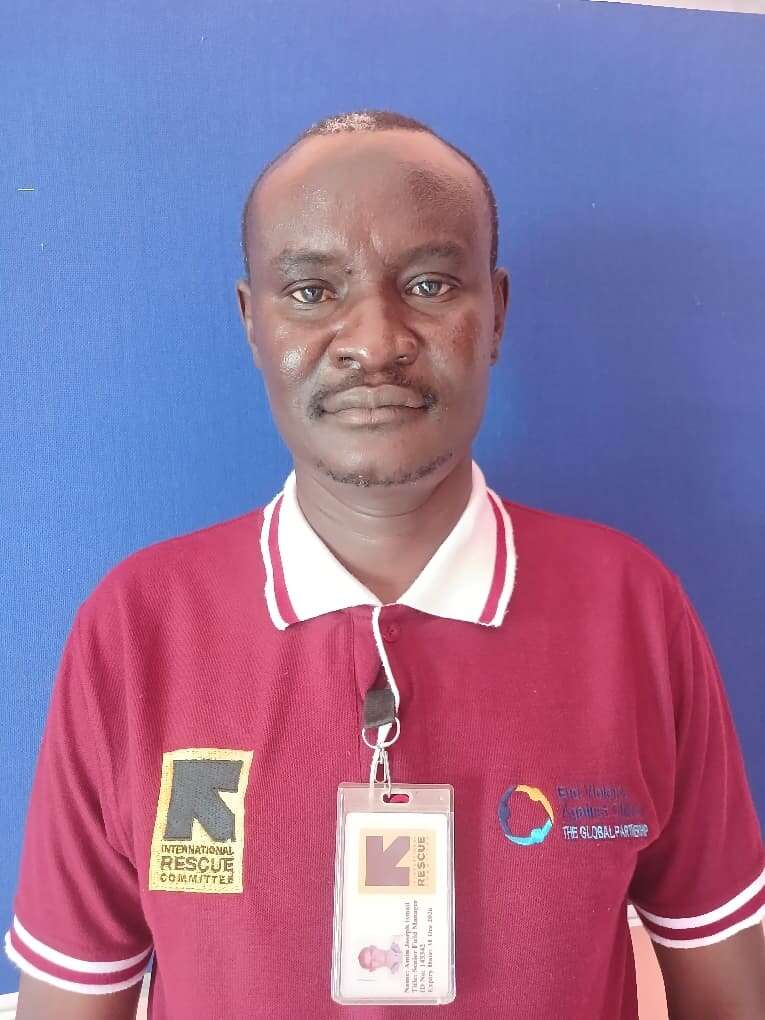 A man in a red shirt looks into the camera