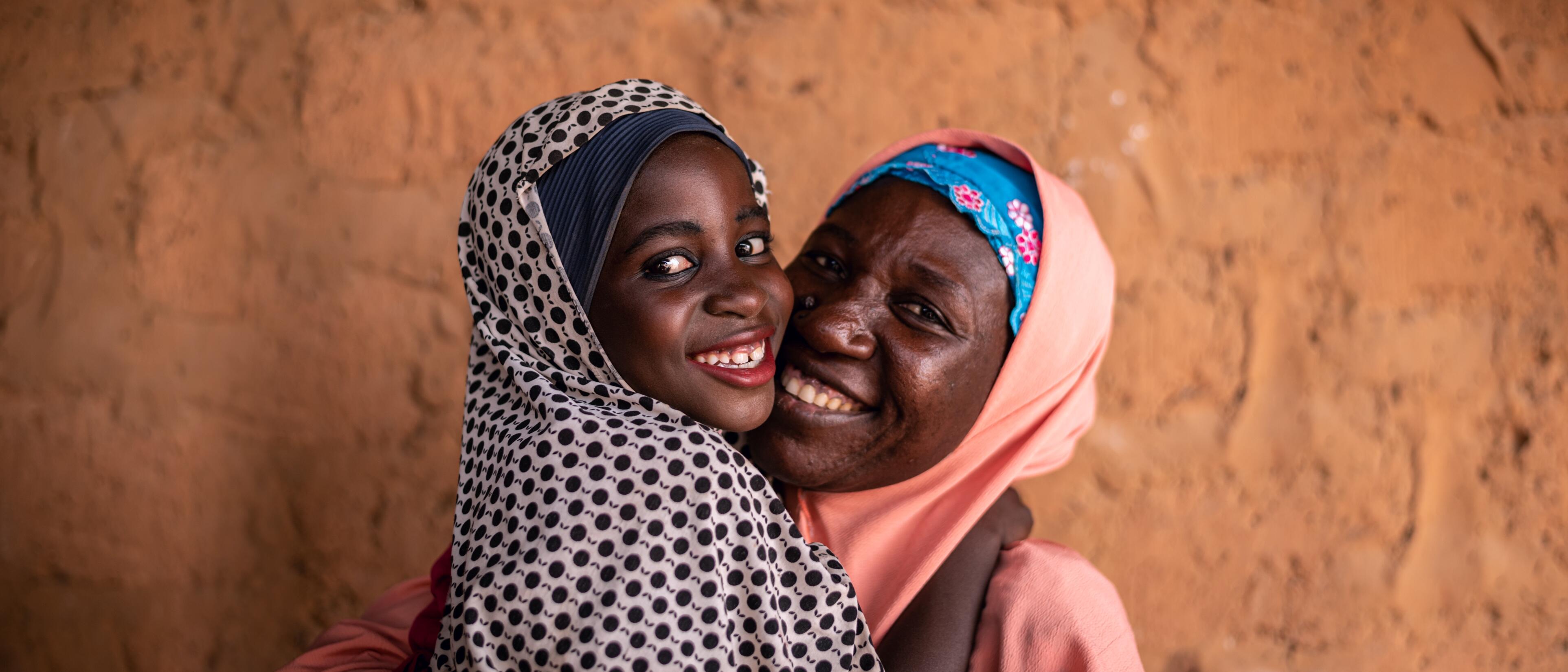 Fatima, age 8, hugs her mother before going to school.