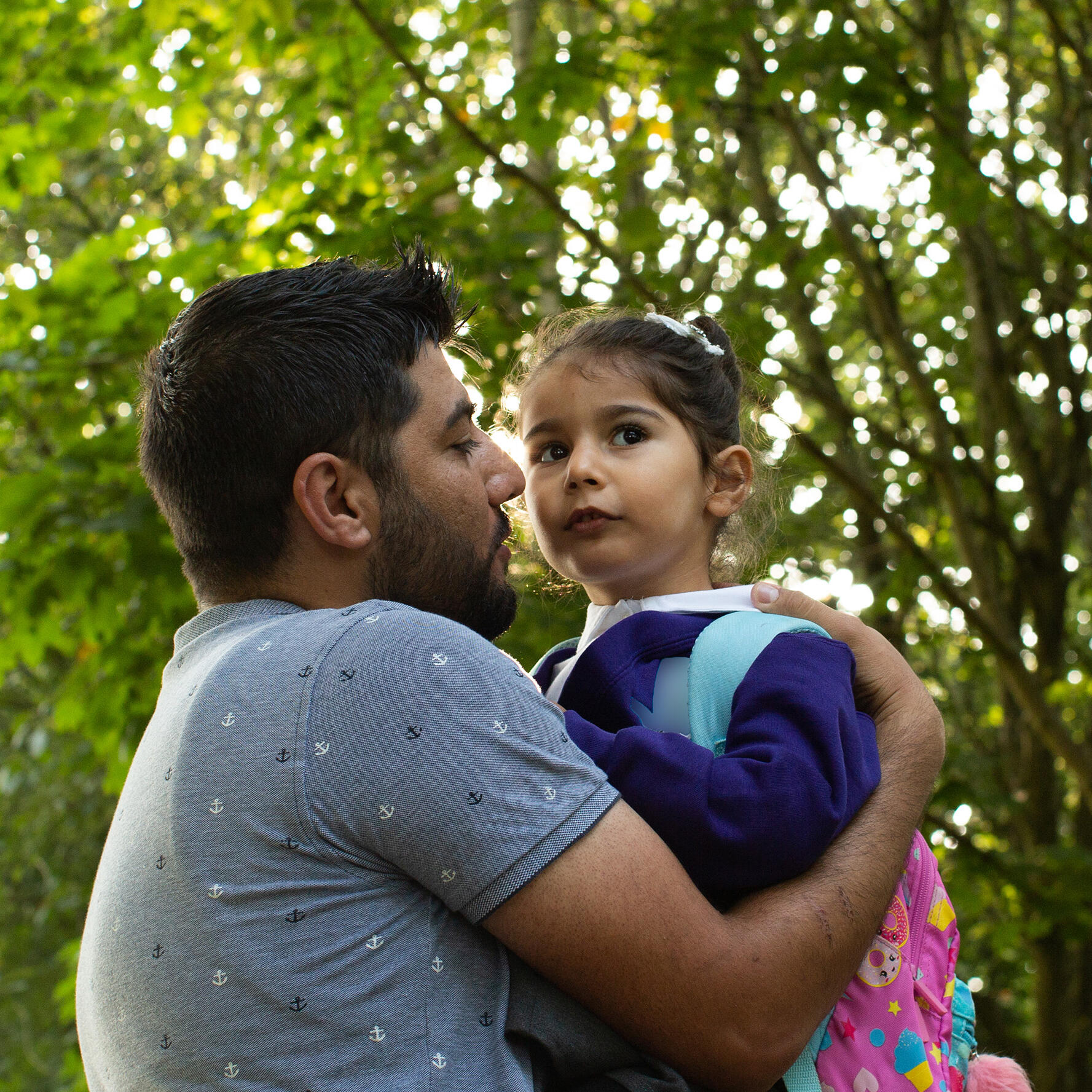 Maasom hugs his daughter Nasrin goodbye on her first day of school.