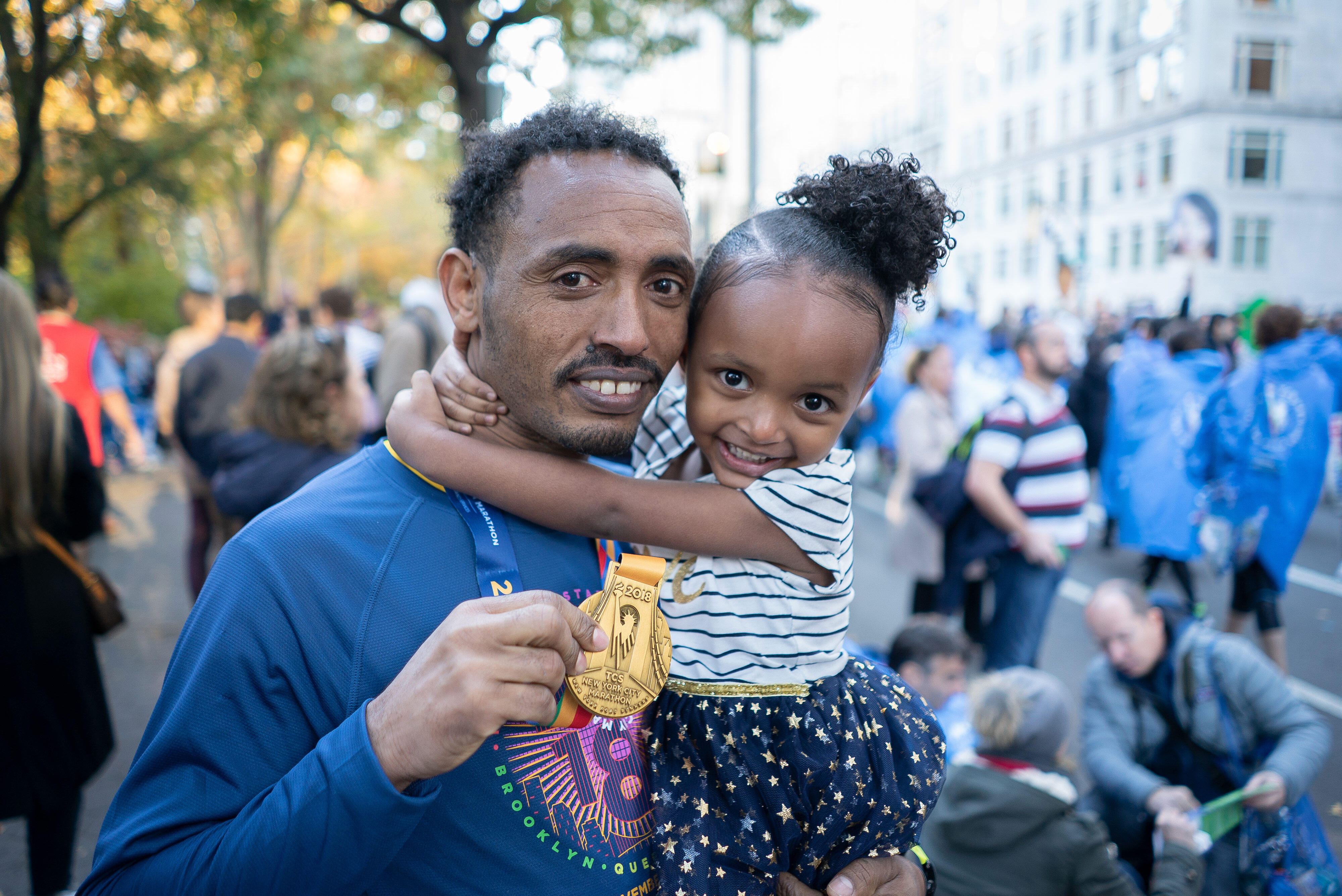 Ethiopian runner Tolassa Elemaa holds his daughter after completing the New York City Marathon on Nov. 7, 2018
