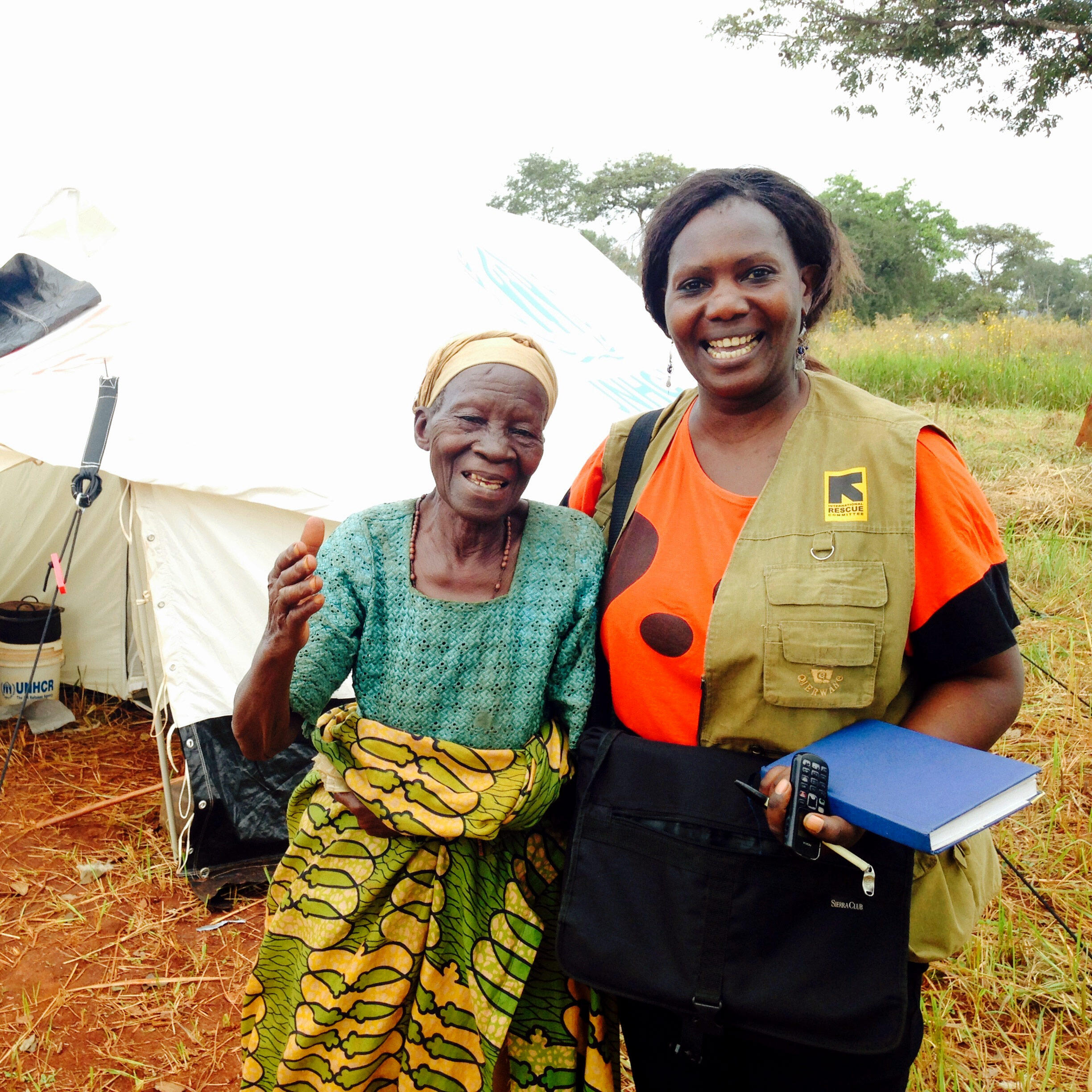 IRC workers poses for photo with elderly Burundian woman in front of tent in Nyaragusu refugee camp in Tanzania.