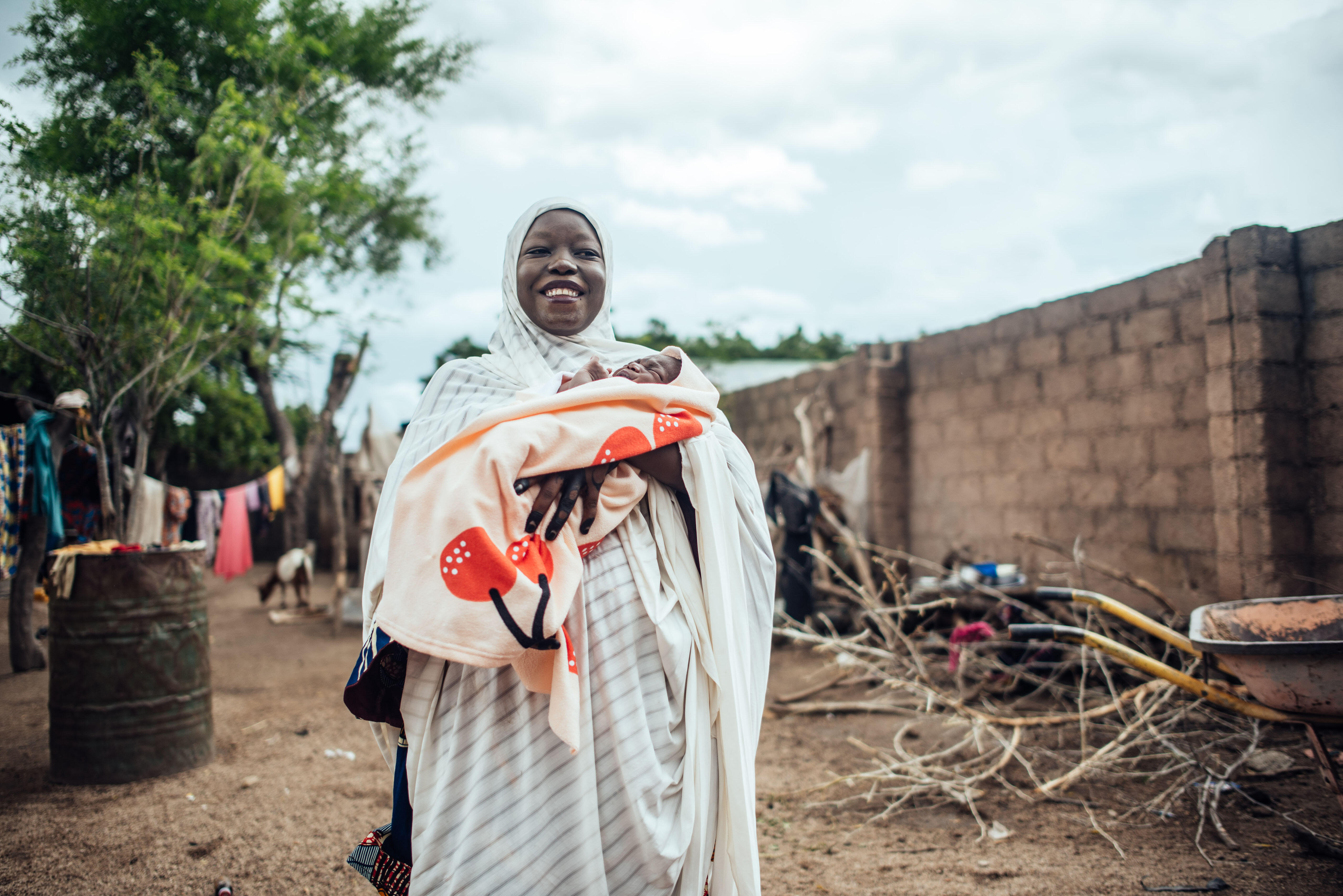 IRC client Hussiena Ibrahim smiles holding her 7 day old baby.