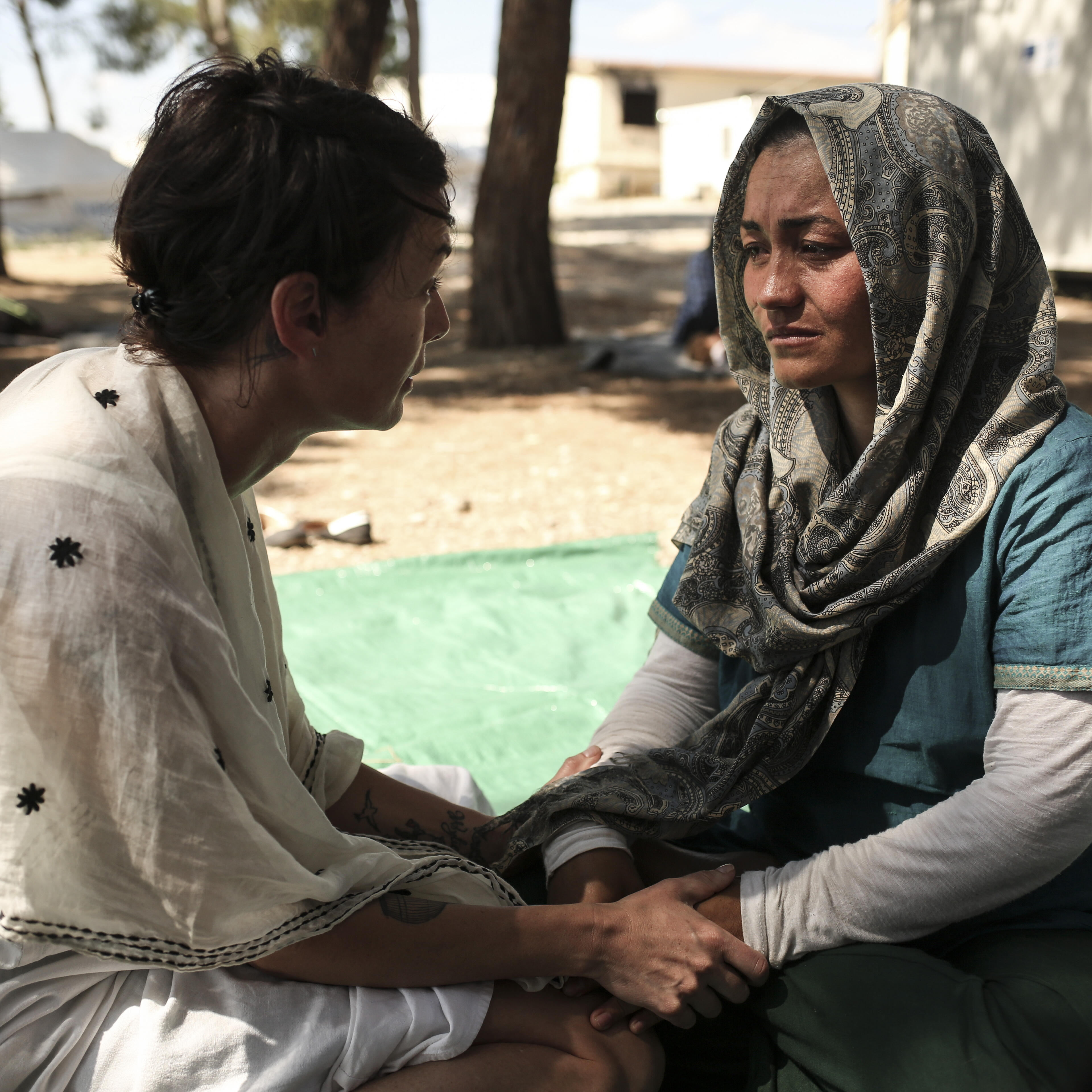 Lena Headey, who plays Cersei Lannister on Game of Thrones, talks with Afghan refugee Rehanna, age 27, holding her hands