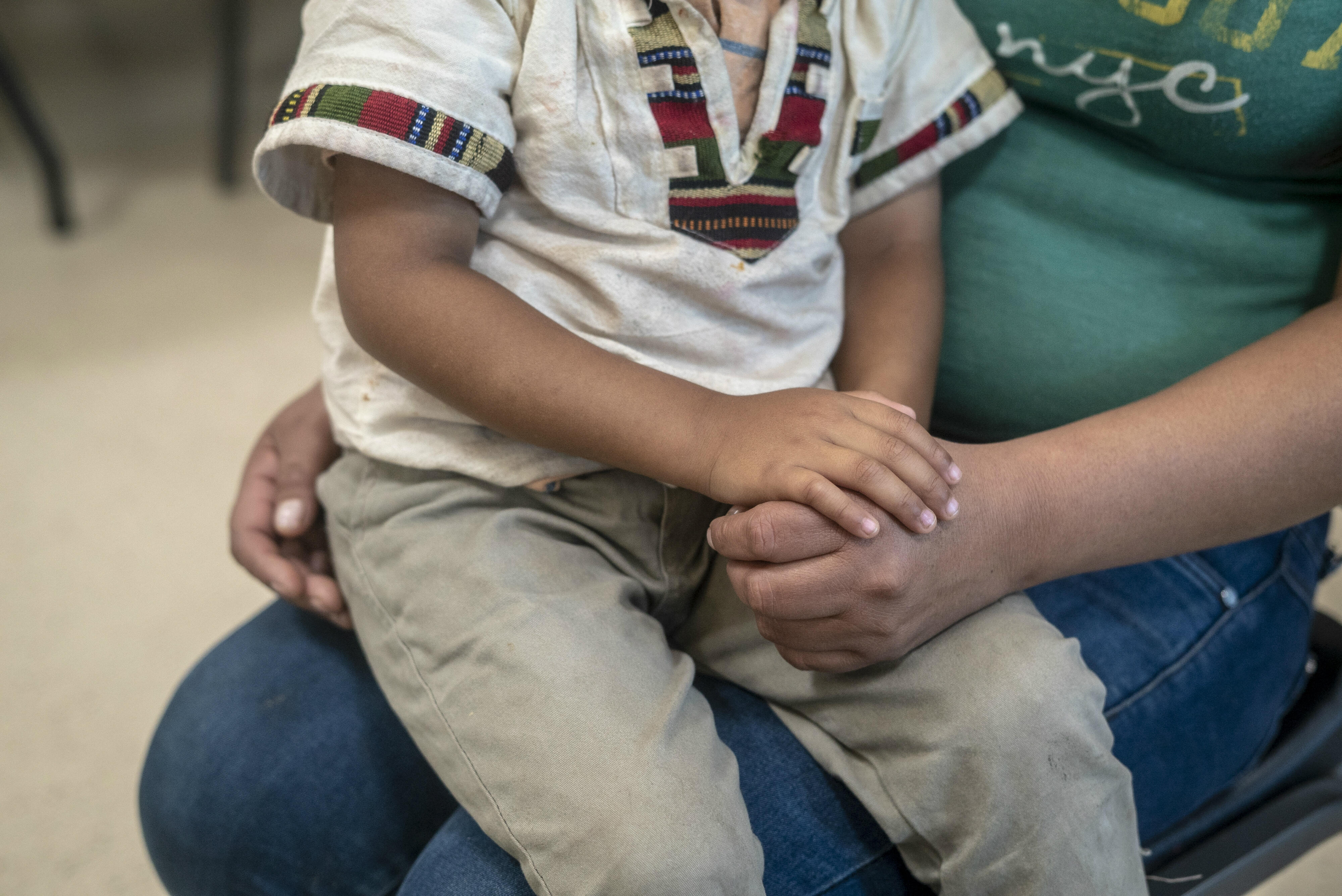 A Central American child sits on his mother's lap