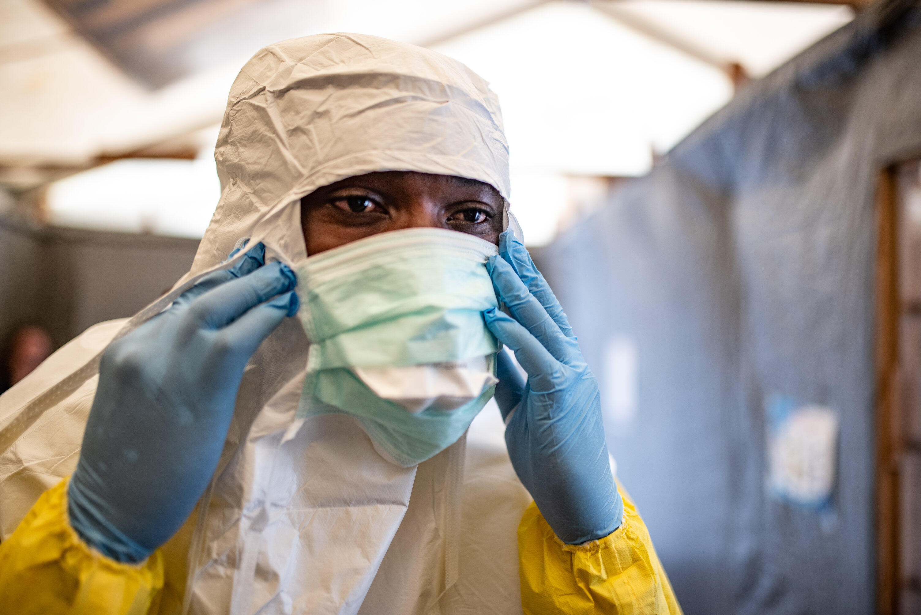 A health worker in the Democratic Republic of Congo puts on a face mask along with other protective equipment to care for patients in an area affected by a deadly Ebola outbreak