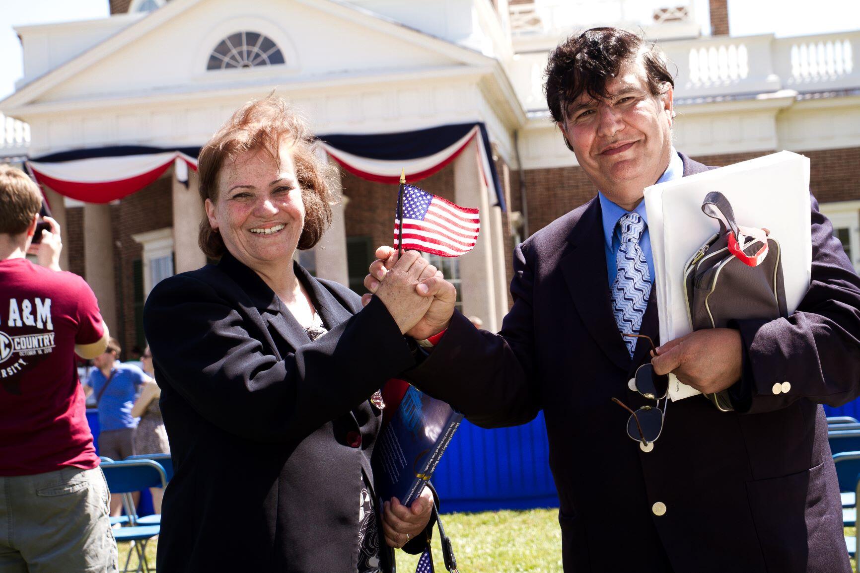 A refugee couple hold an American flag at their naturalization ceremony in Charlottesville, VA/