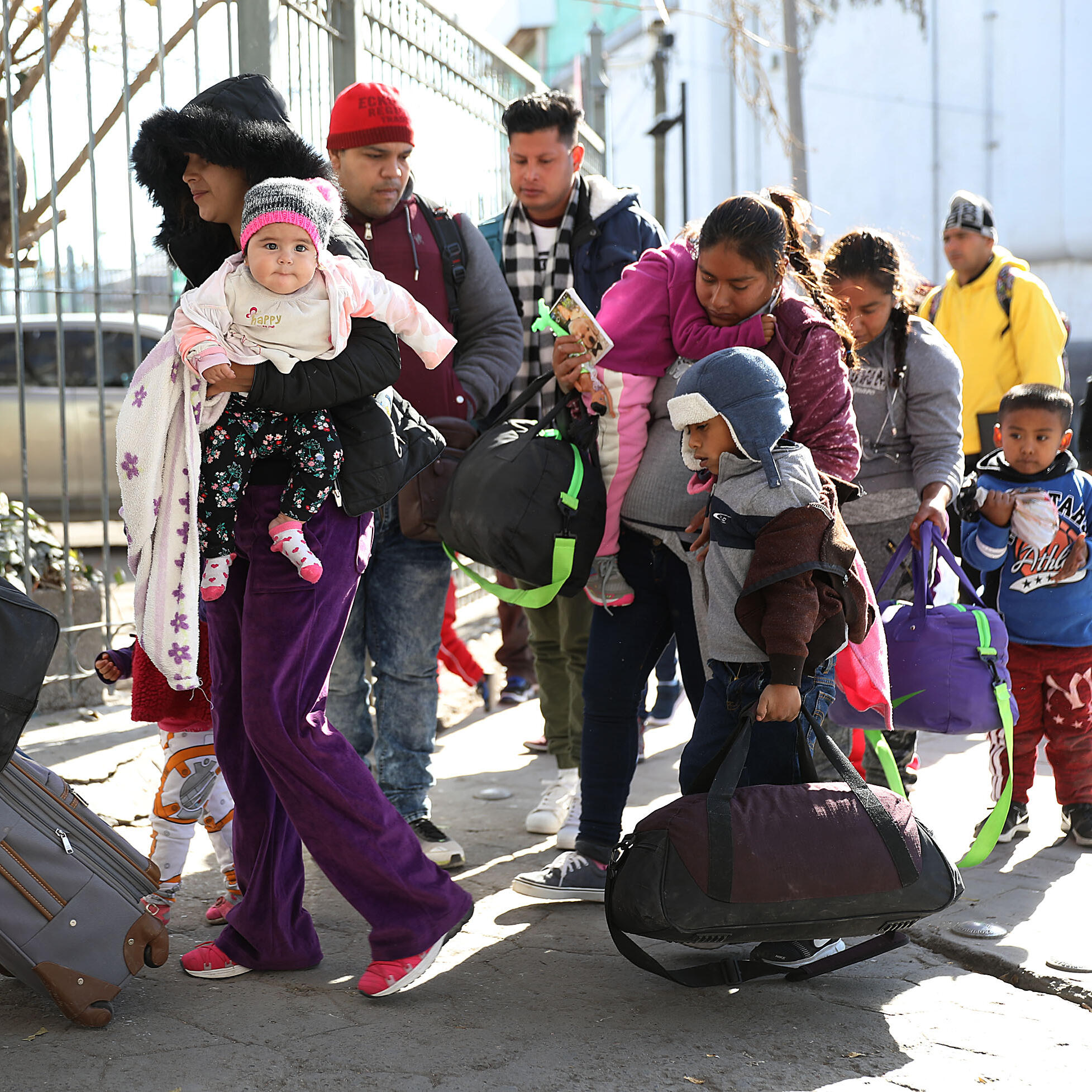Central American families stand in line, waiting to present themselves to U.S. immigration authorities at the U.S.-Mexico border near Ciudad Juarez, Mexico. 