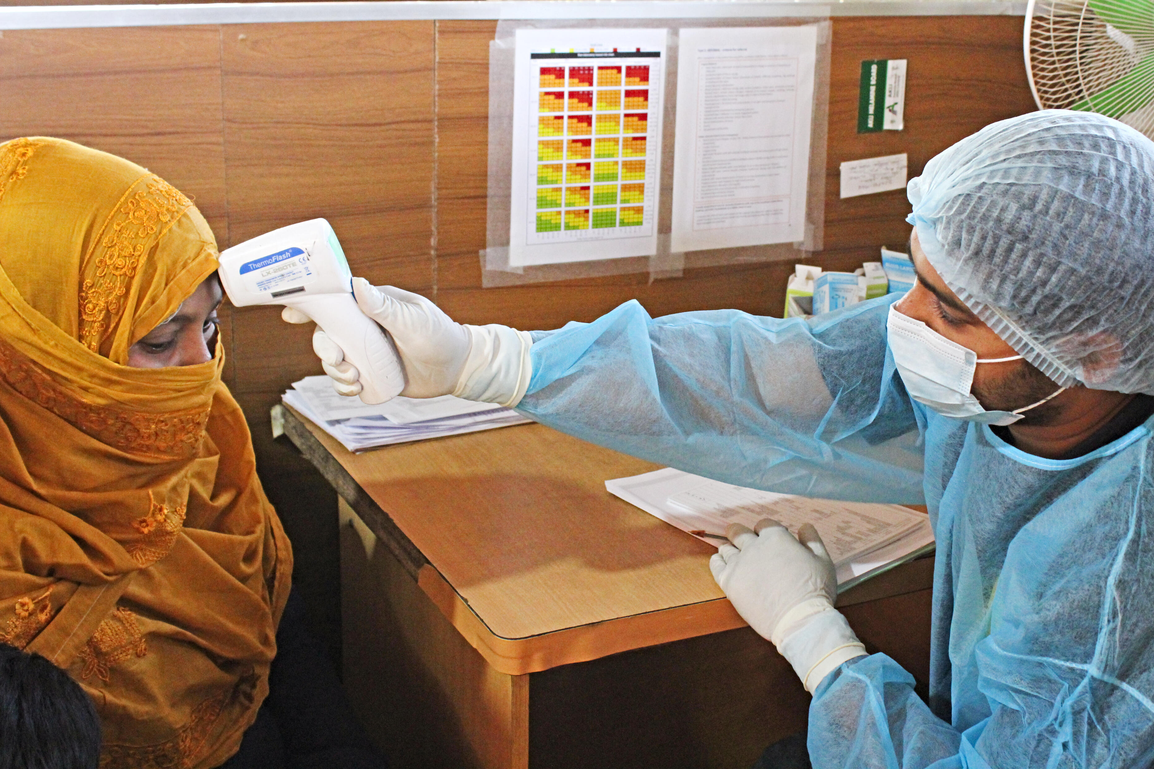 An IRC paramedic checks the temperature of a woman in Cox's Bazar refugee camp in Bangladesh