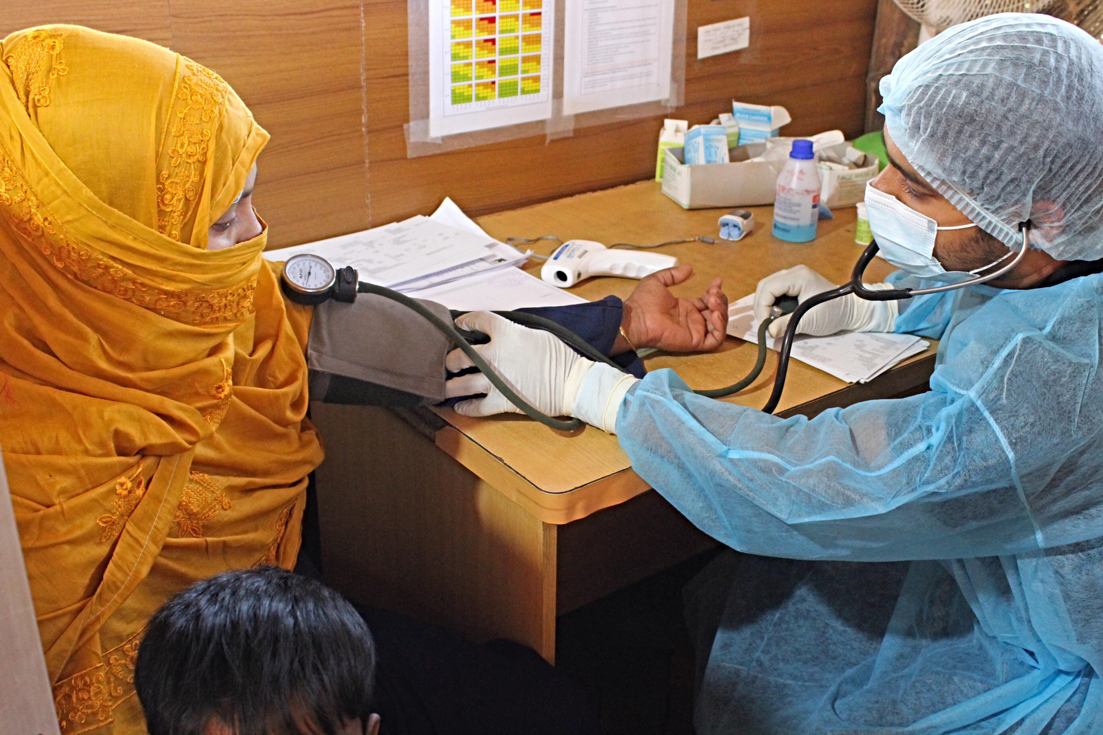 A paramedic takes the blood pressure reading of a young woman in Bangladesh