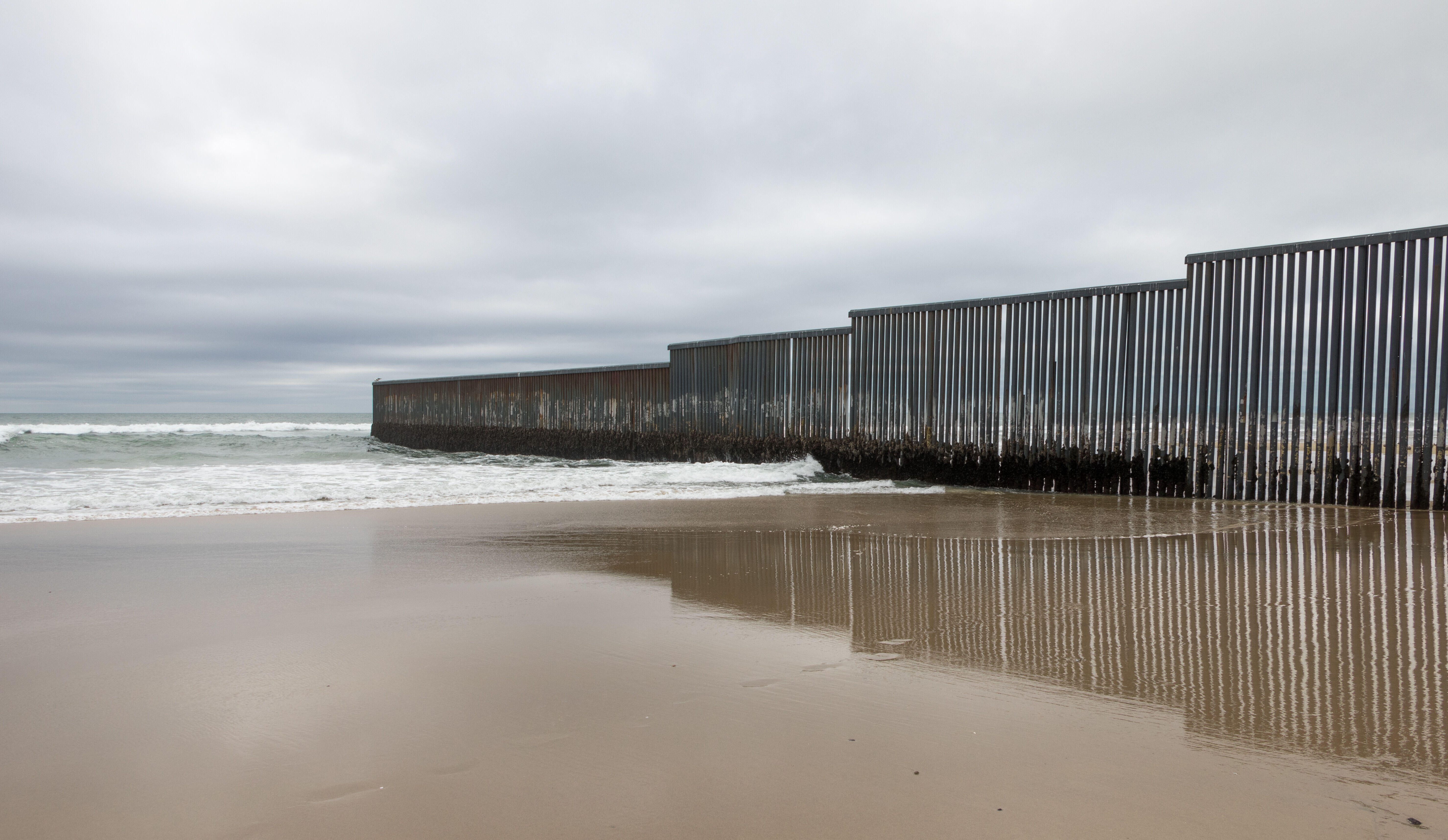 On a beach on the U.S.-Mexico border at Tijuana, Mexico, a border wall extends into the ocean 