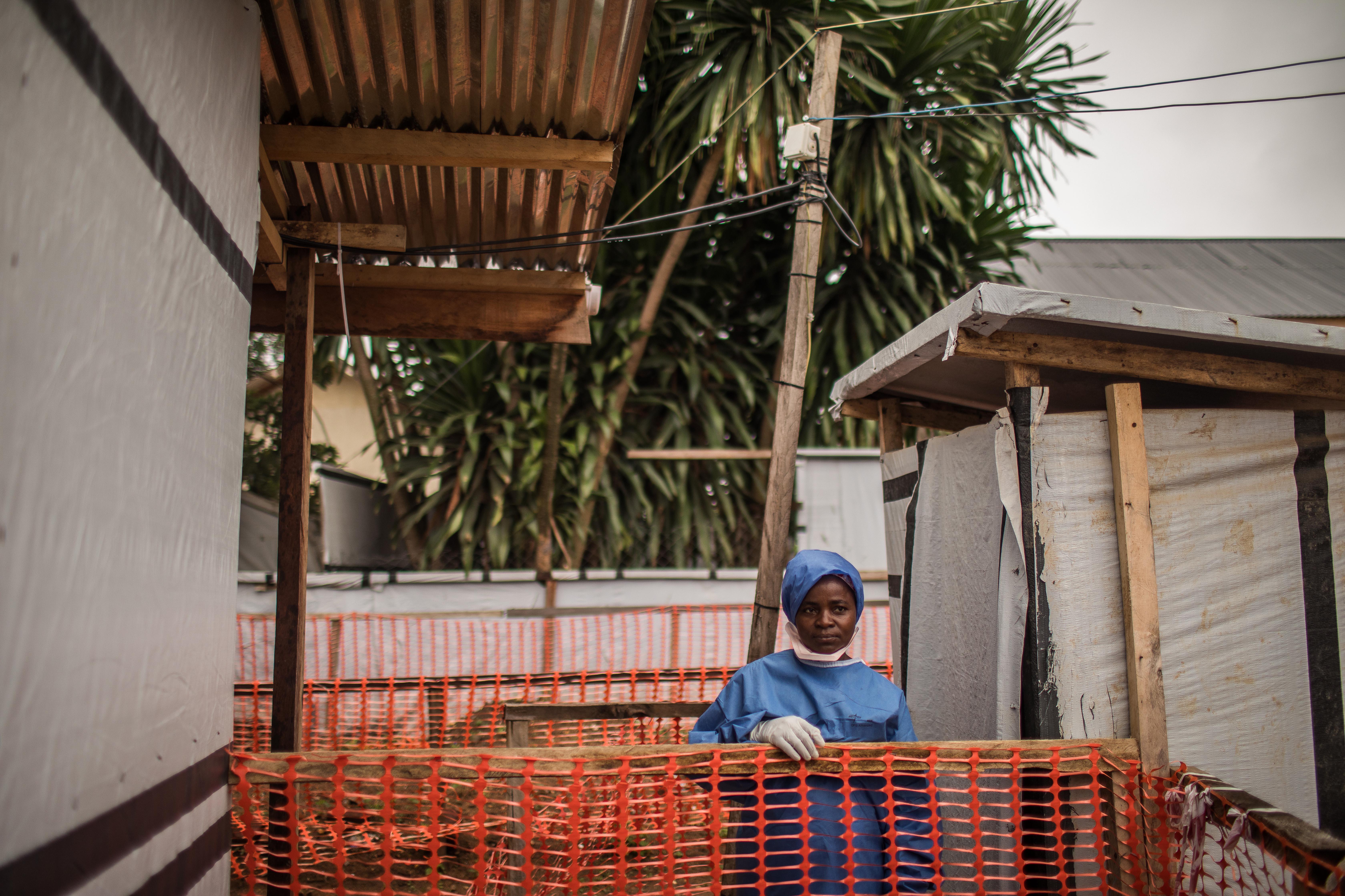 Ebola survivor Kahindo Kamala, wearing PPE, stands outside the Ebola treatment unit at hospital where she works in eastern Democratic Republic of Congo