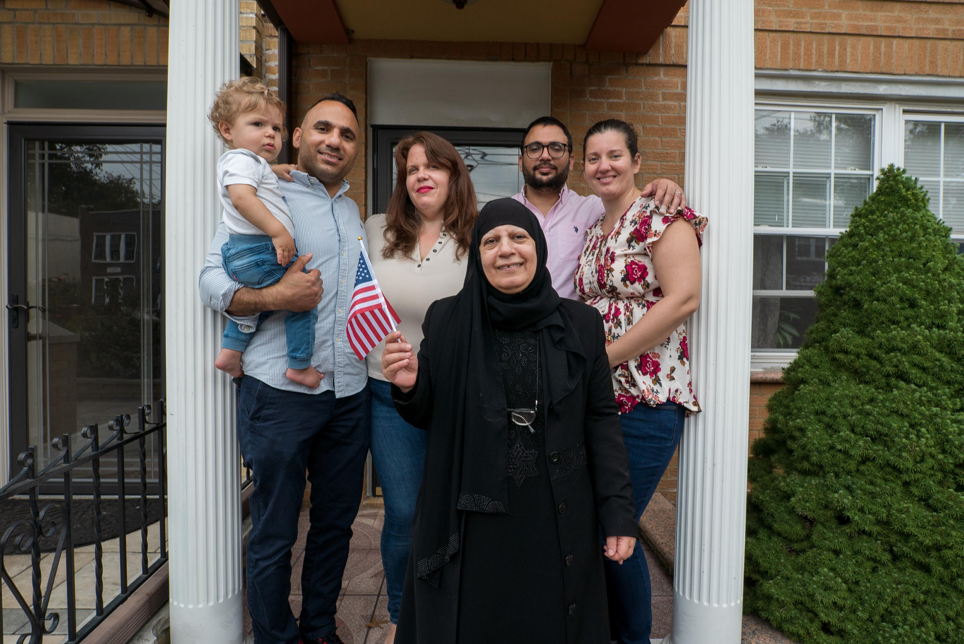 Maha al-Obaidi, 66, stands with her family outside their home in New York.
