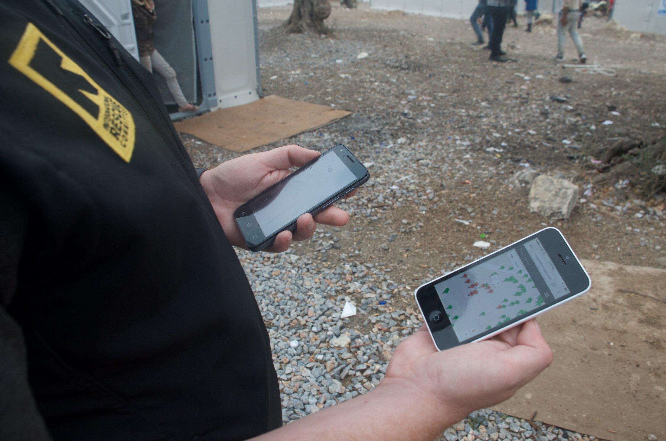 An IRC aid worker in Greece looks at an IRC  shelter mapping app on a smartphone. Photo: Kulsoom Rizvi/IRC 