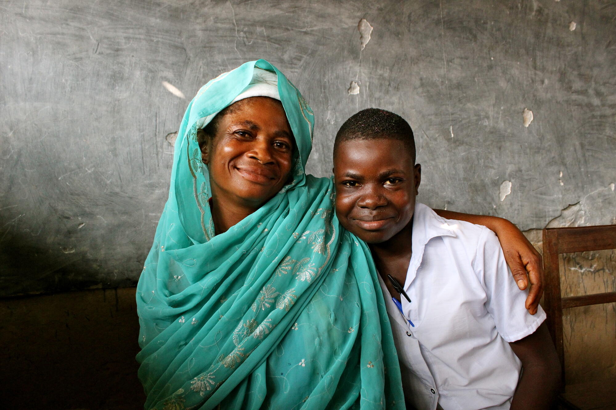 a woman and boy smile at the camera