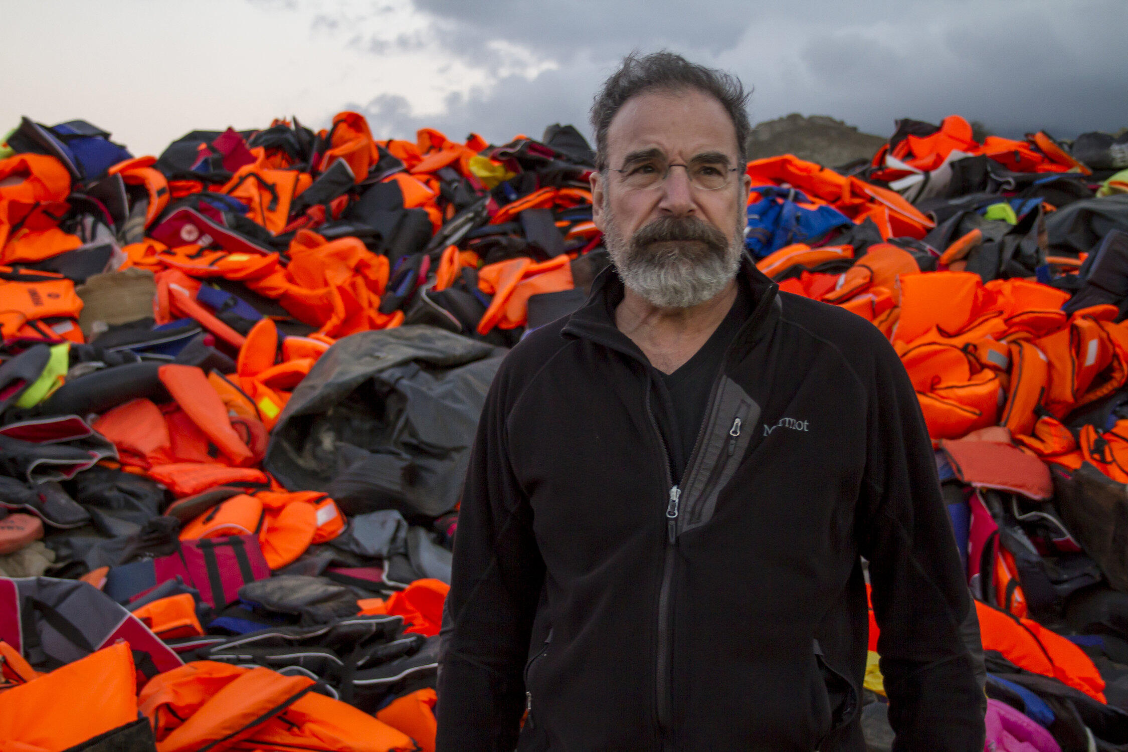 Mandy Patinkin on the island of Lesbos, Greece with lifejackets used by refugee