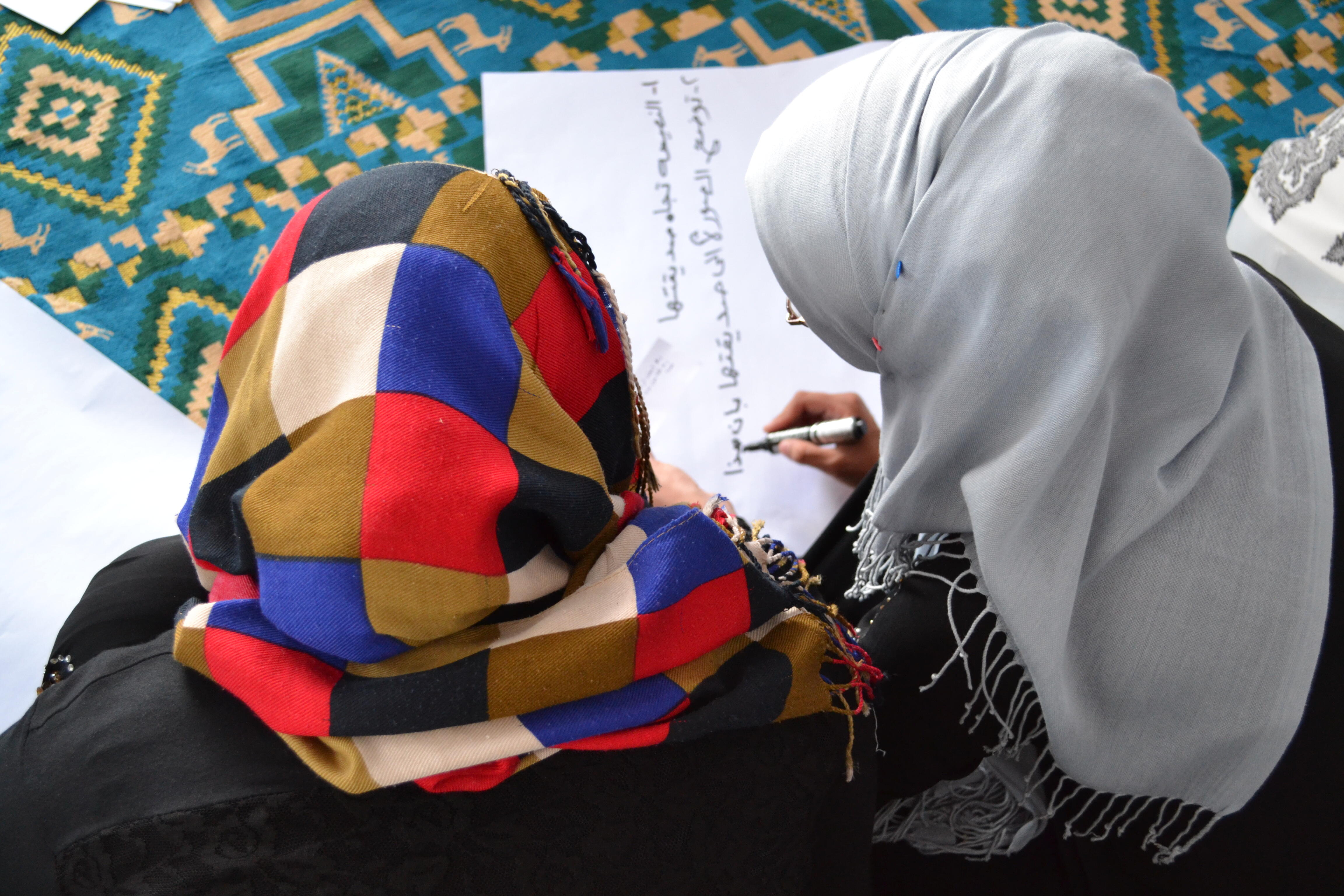 Girls listen in the women's center as IRC social workers explain that every problem has a solution as part of the day's activity