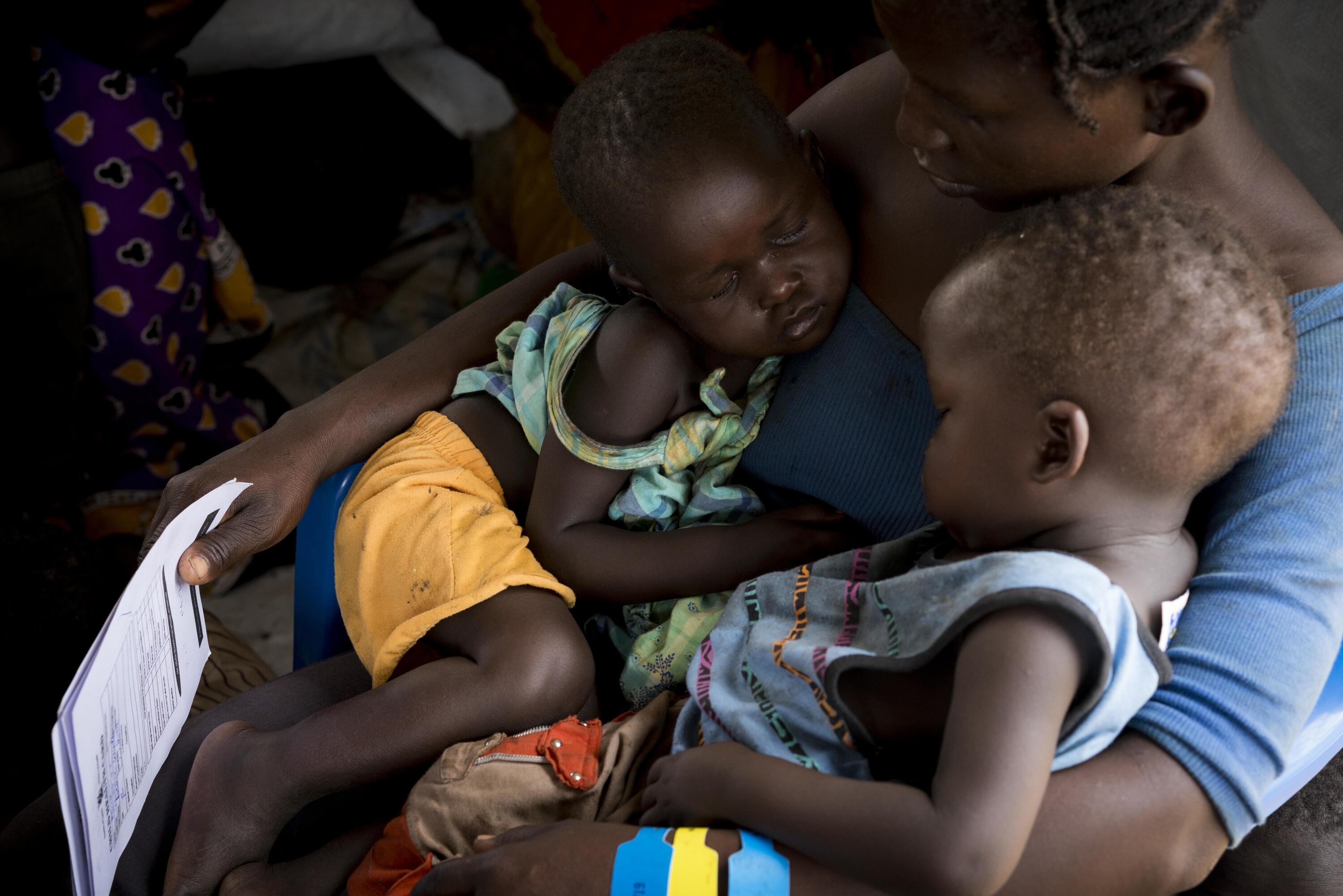 Two-year-old twins, Martin and Desire, sleep on their mother's lap at the registration centre at the Imvepi refugee settlement for South Sudanese who have crossed into northern Uganda, March 3, 2017.