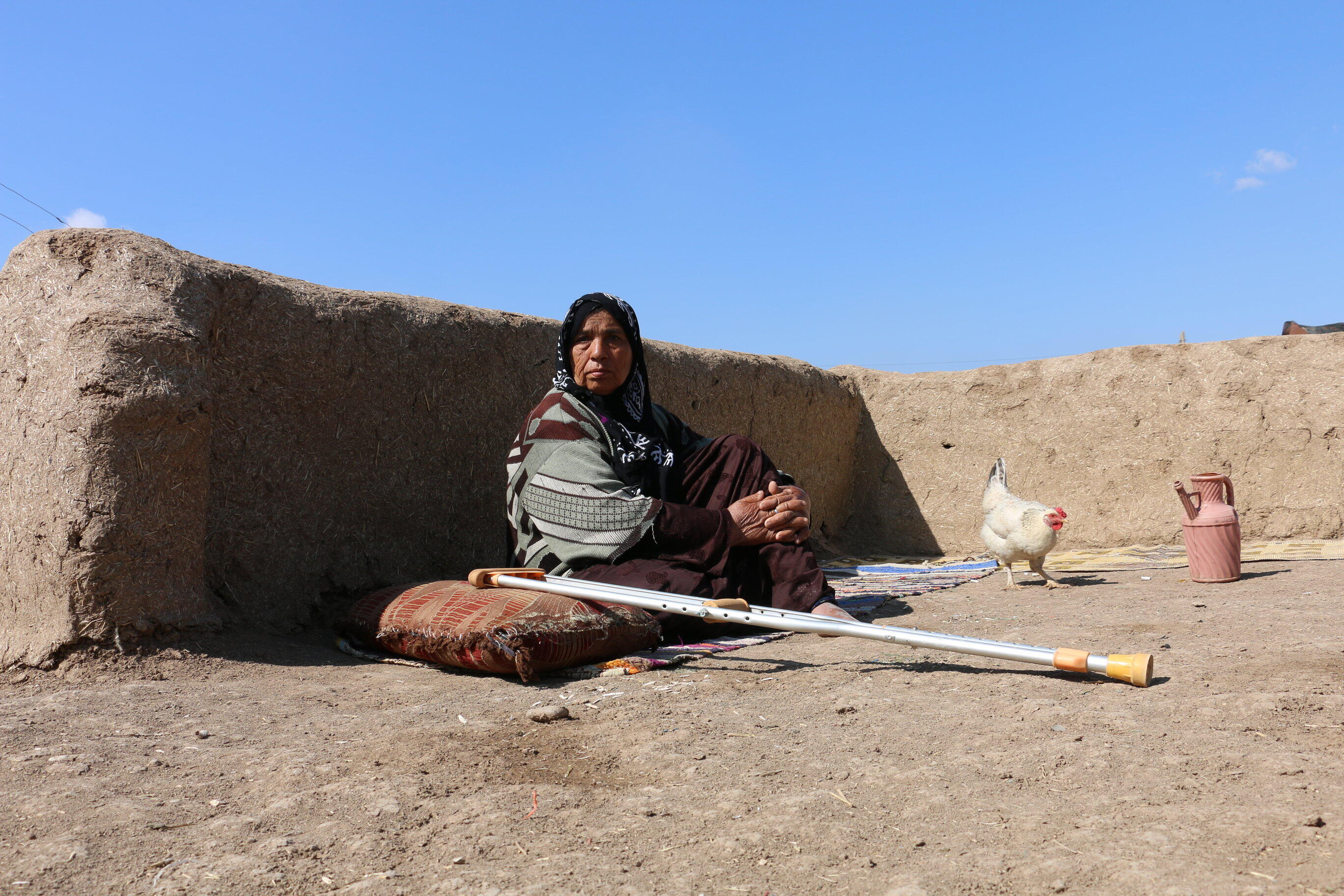 Miriam sits on a mat outside her home in Syria to get fresh air. 