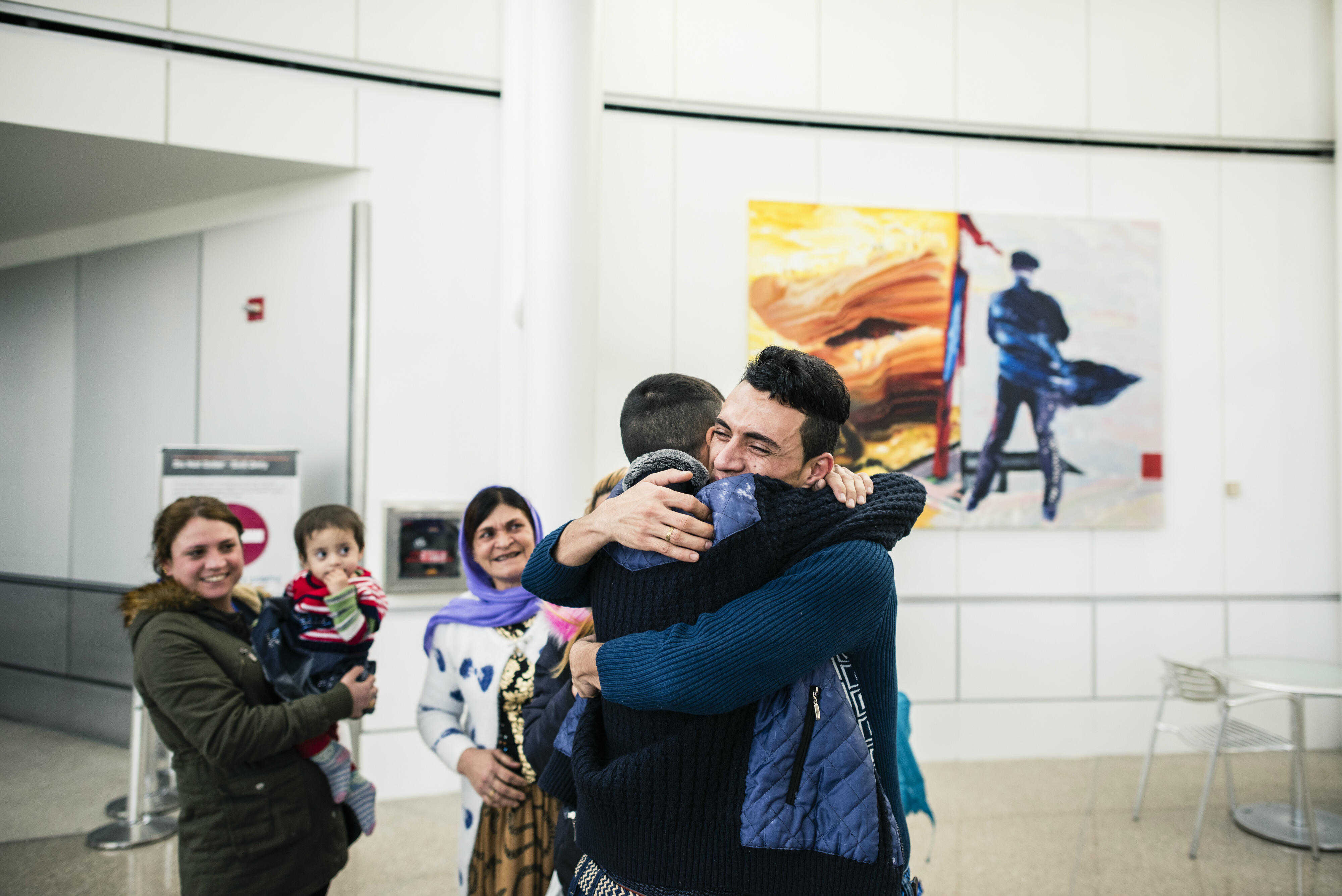 Adil Nimr, a refugee from Iraq, hugs one of his relatives at the airport after arriving in Seattle.