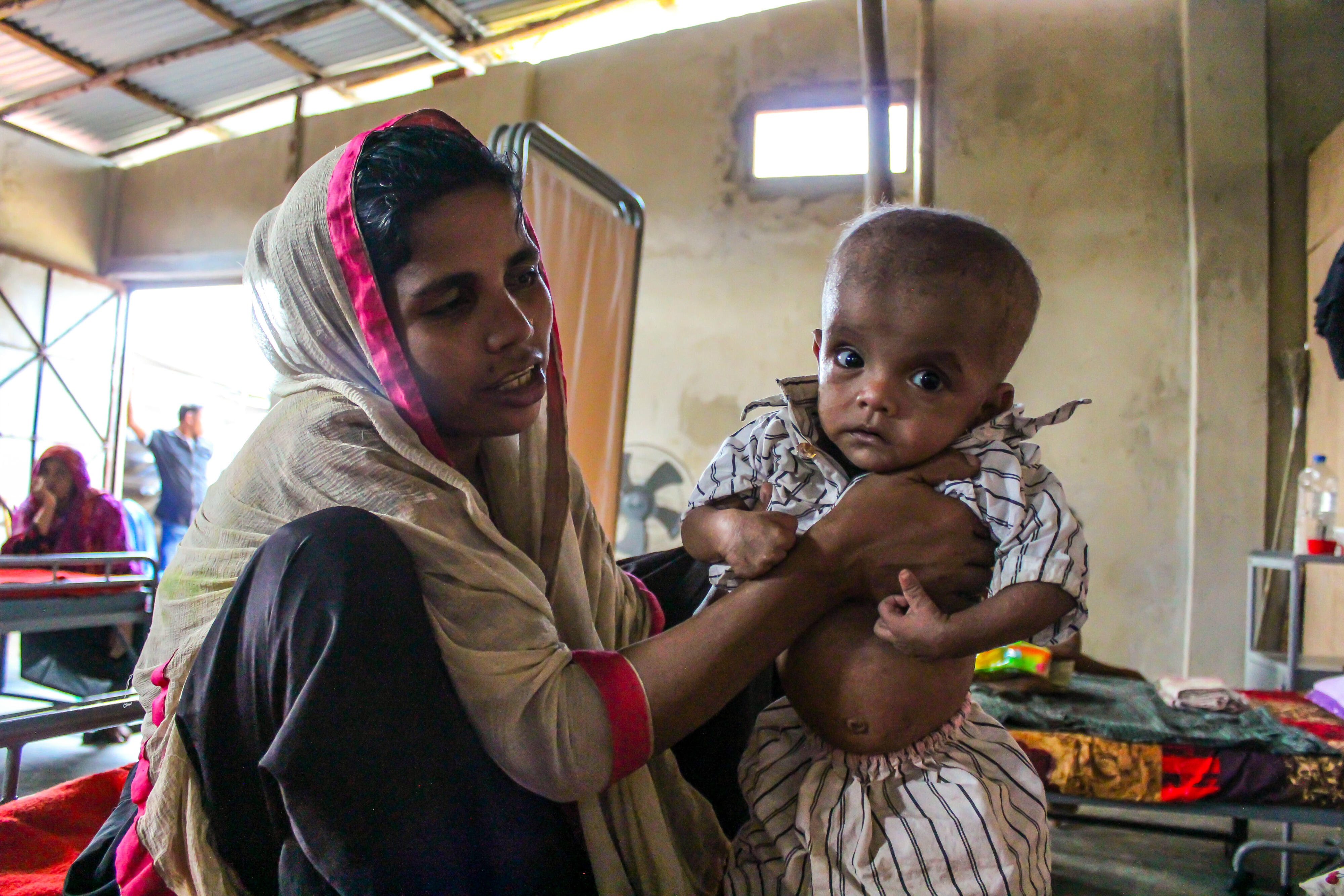 A Rohingya refugee woman holds her malnourished baby in an IRC-supported health center in Bangladesh.