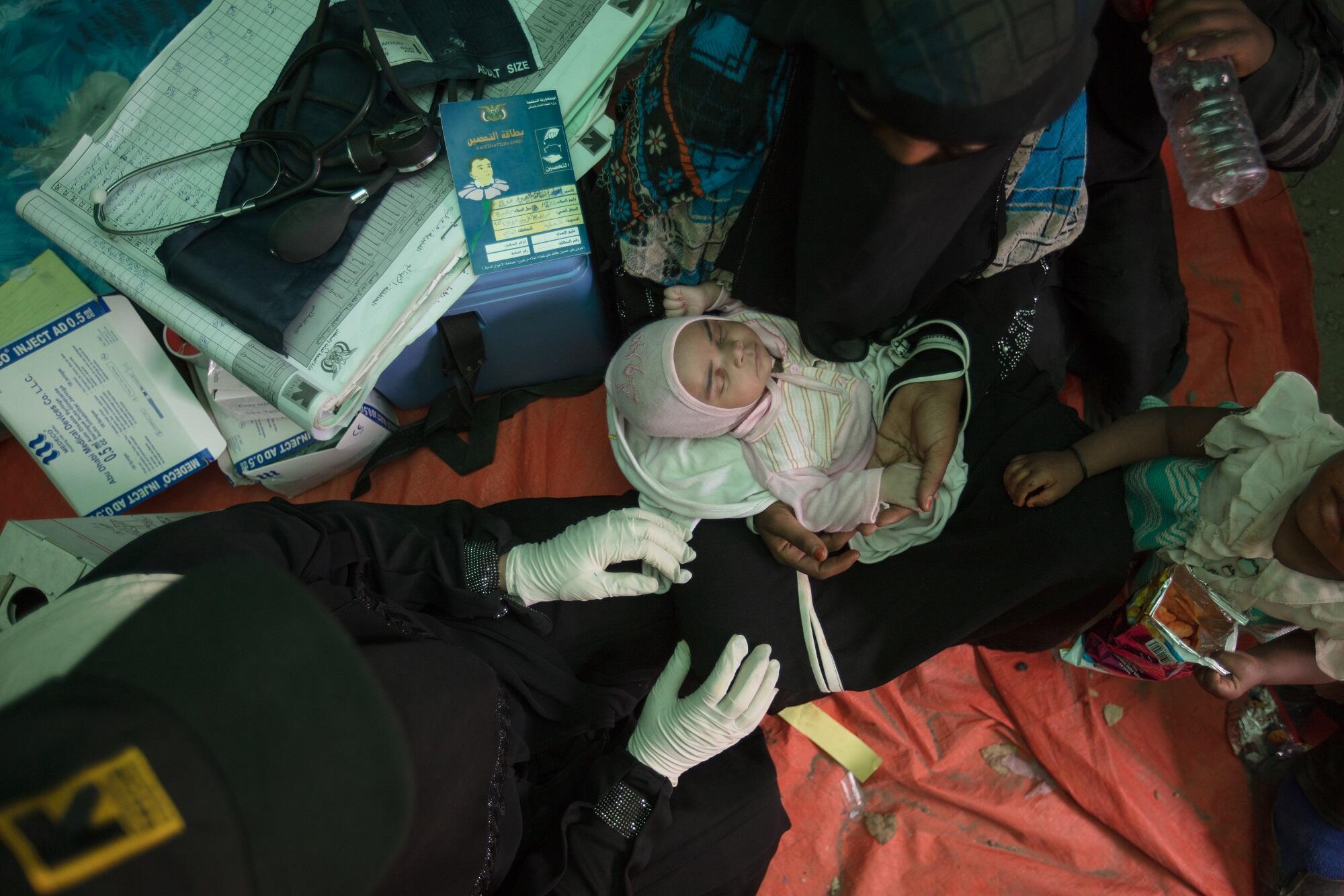 Baby Enkath receiving a check-up from IRC midwife Samya.