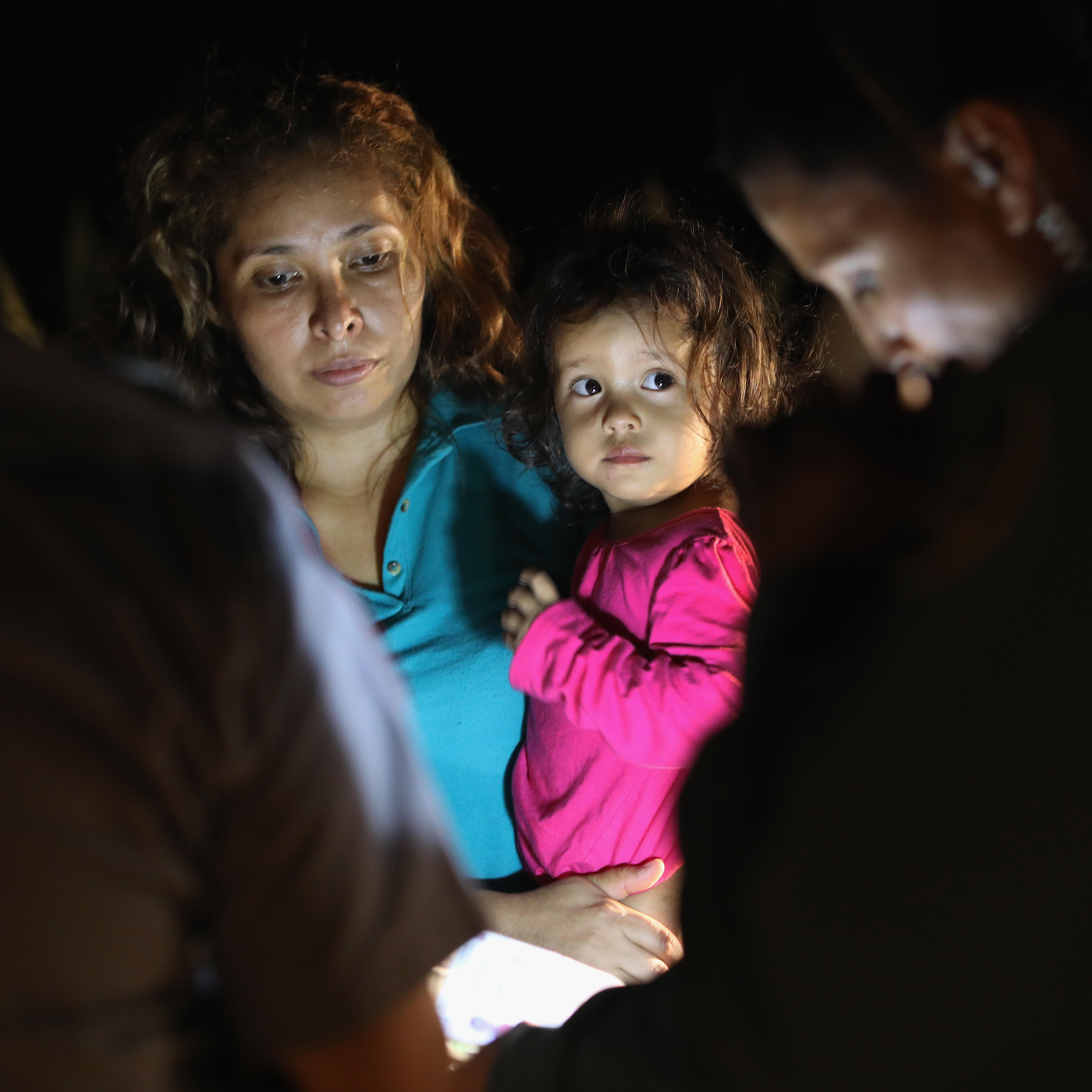 A two-year-old child and her mother from Honduras are taken into custody near the U.S.-Mexico border in McAllen, Texas.