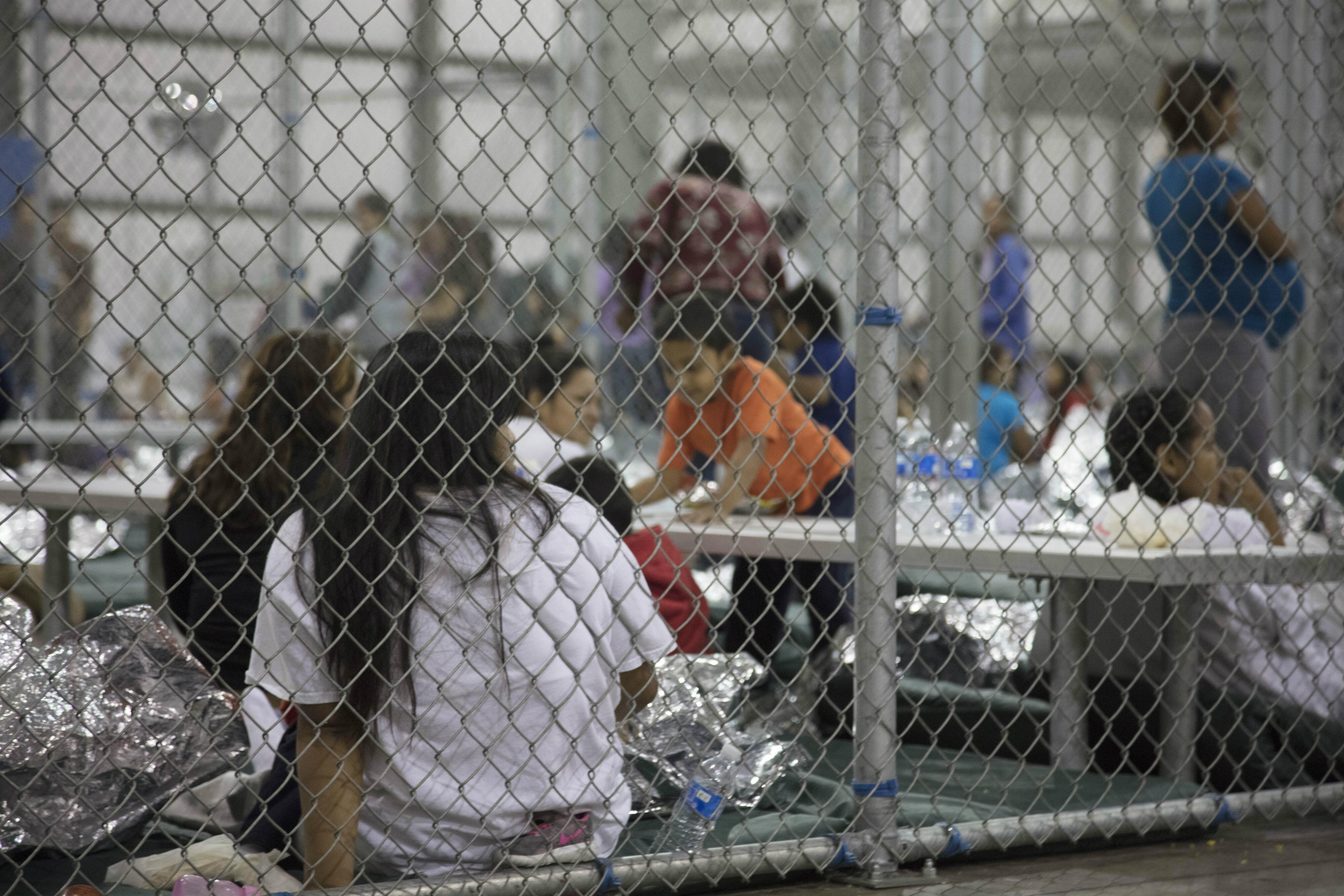 Families detained behind a chain-link fence inside a U.S. Border Patrol facility in Texas 