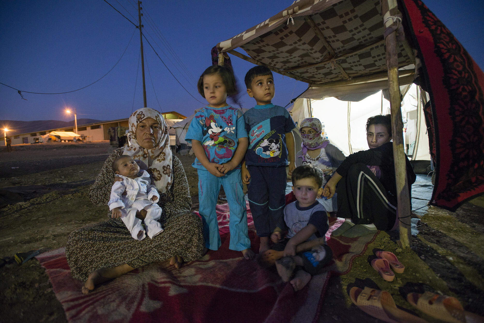 A family made homeless by violence sits outside their makeshift shelter in northern Iraq