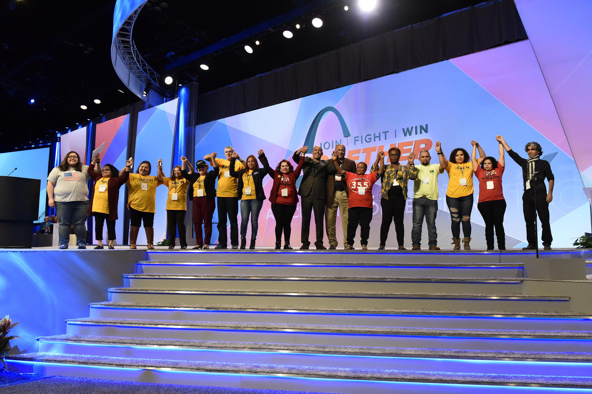 Tefere Gebre stands onstage with a group of new Americans at the AFL-CIO's 2017 conference in St. Louis