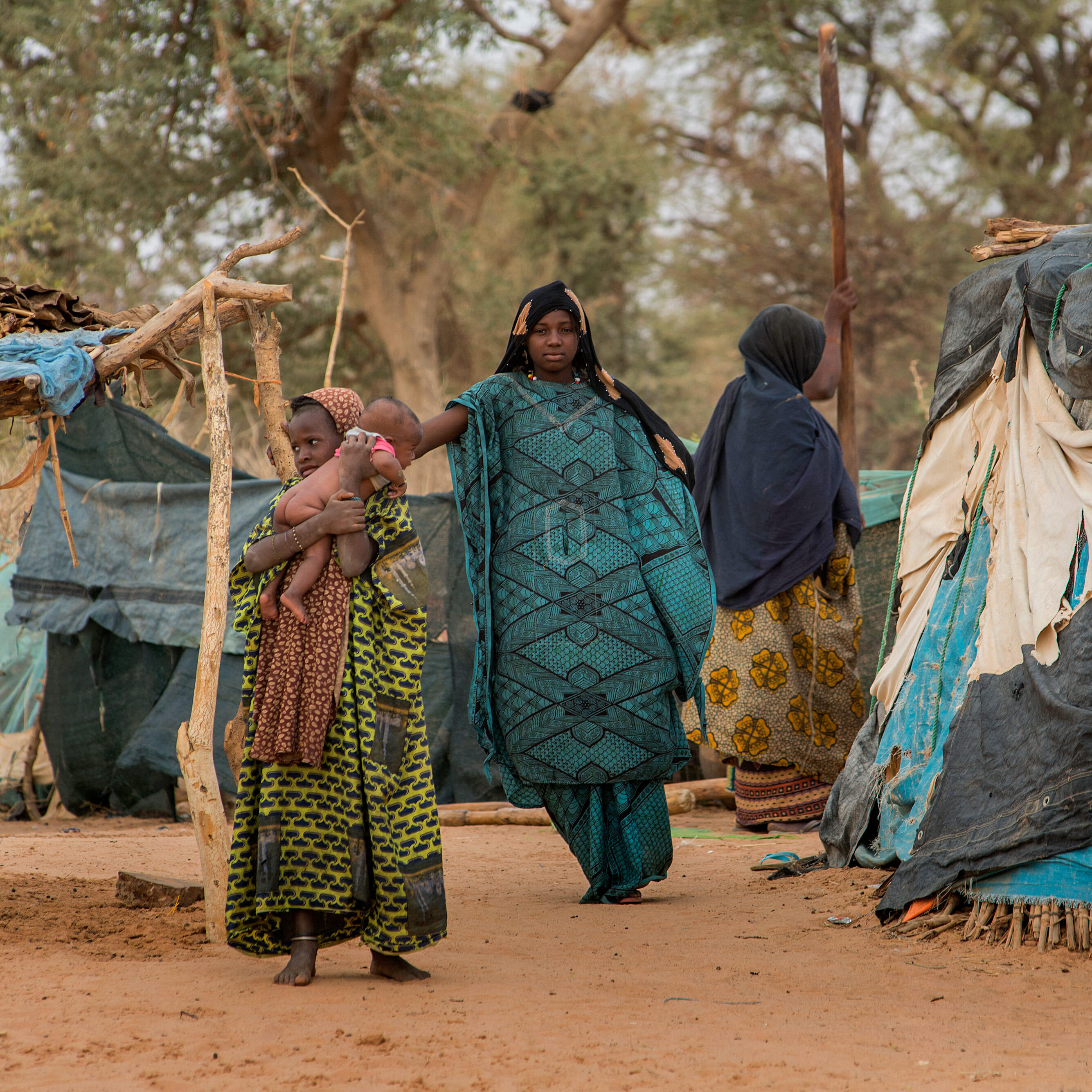 A family standing next to a hut.
