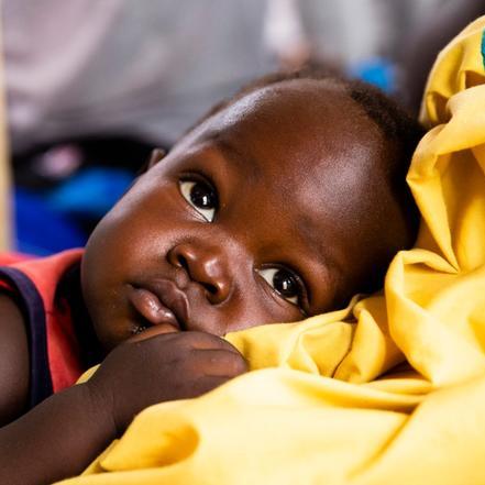 남수단 의료 시설에서 한 아기가 어머니에게 안겨 있습니다.