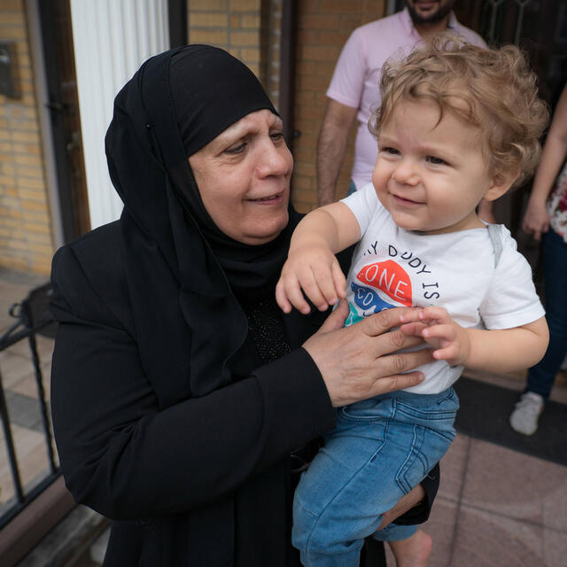 Maha holds her grandson Maha holds her grandson and looks at him smiling.