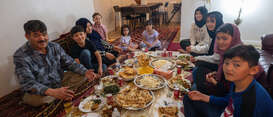 The family sit around their prepared Iftar meal.