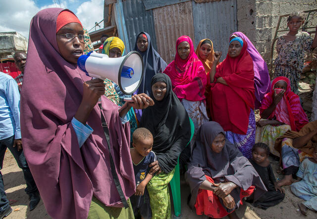 A woman with a megaphone shouting to a group of women