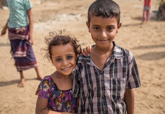 a boy and a girl smiling to camera