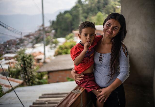 A young woman with her baby on a balcony