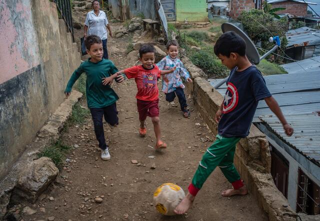 kids playing football in a narrow street