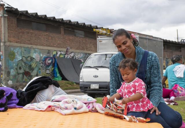 A woman with a playing baby on a public place