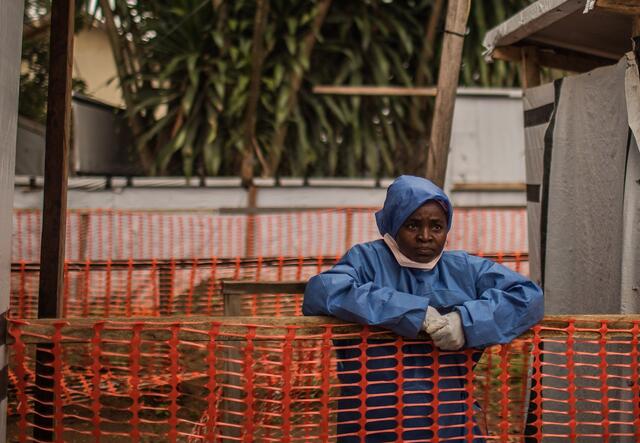 Kamala Kahindo leaning over a fence in hygiene clothing