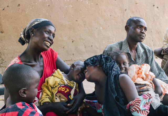 Mother, Father and some children sitting together and looking happy