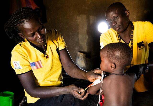 Two IRC workers treat a young boy