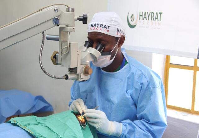 doctor looking in microscope and operating an eye