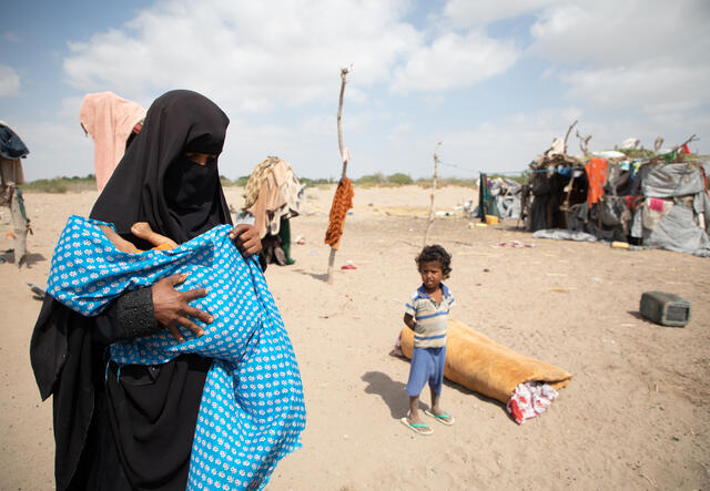 En mor tillsammans med sina två barn utanför deras tillfälliga hem i Syrien.