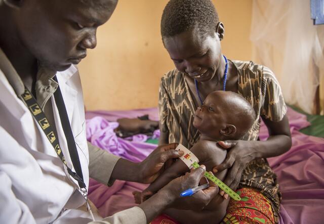 A doctor measuring the width of a child's arm