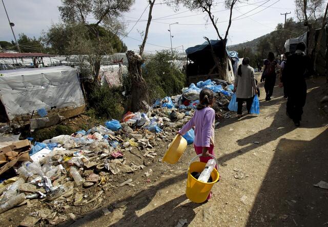 A refugee girl walks through Moria, Greece, where severely overcrowding has lead to dangerous conditions.