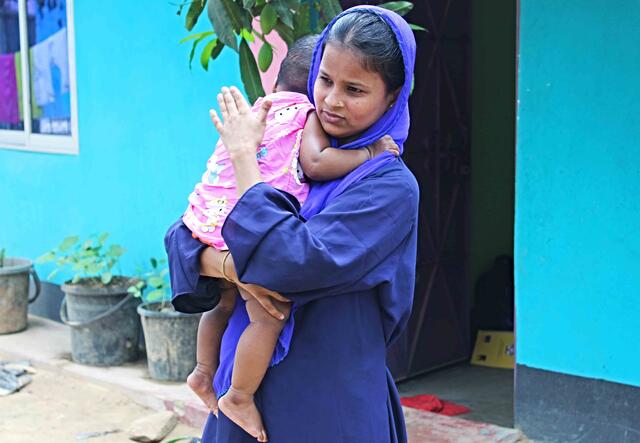 IRC-Hebamme Lovely Akter hält ihre Tochter im Arm